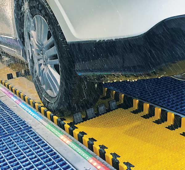 car on a yellow conveyor belt in a car wash