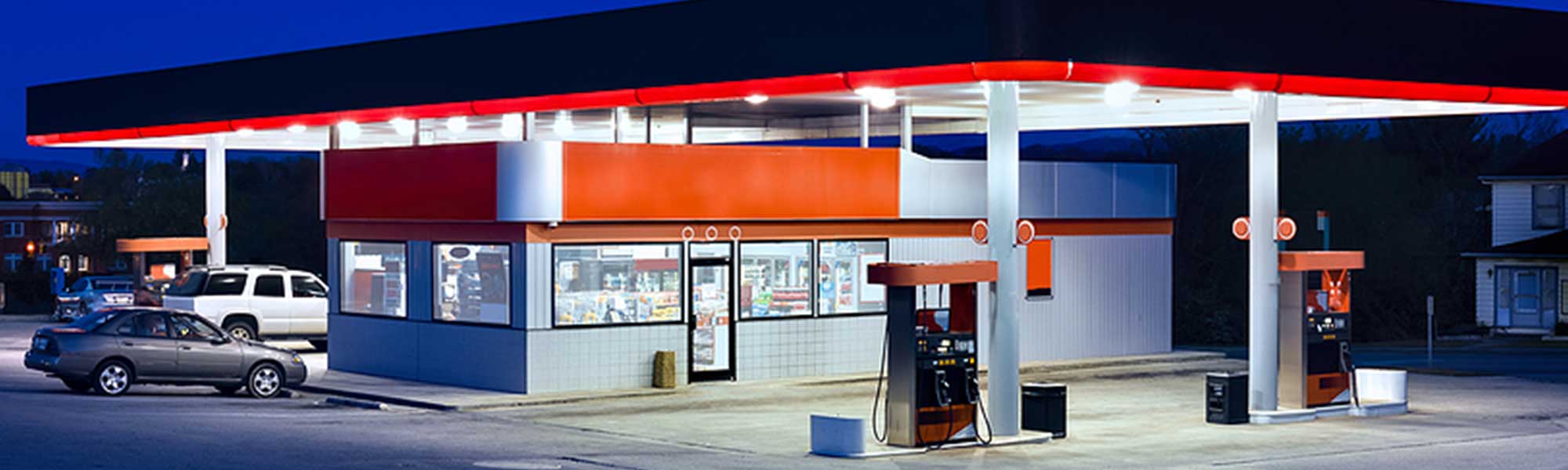 a convenience store with gas pumps at night